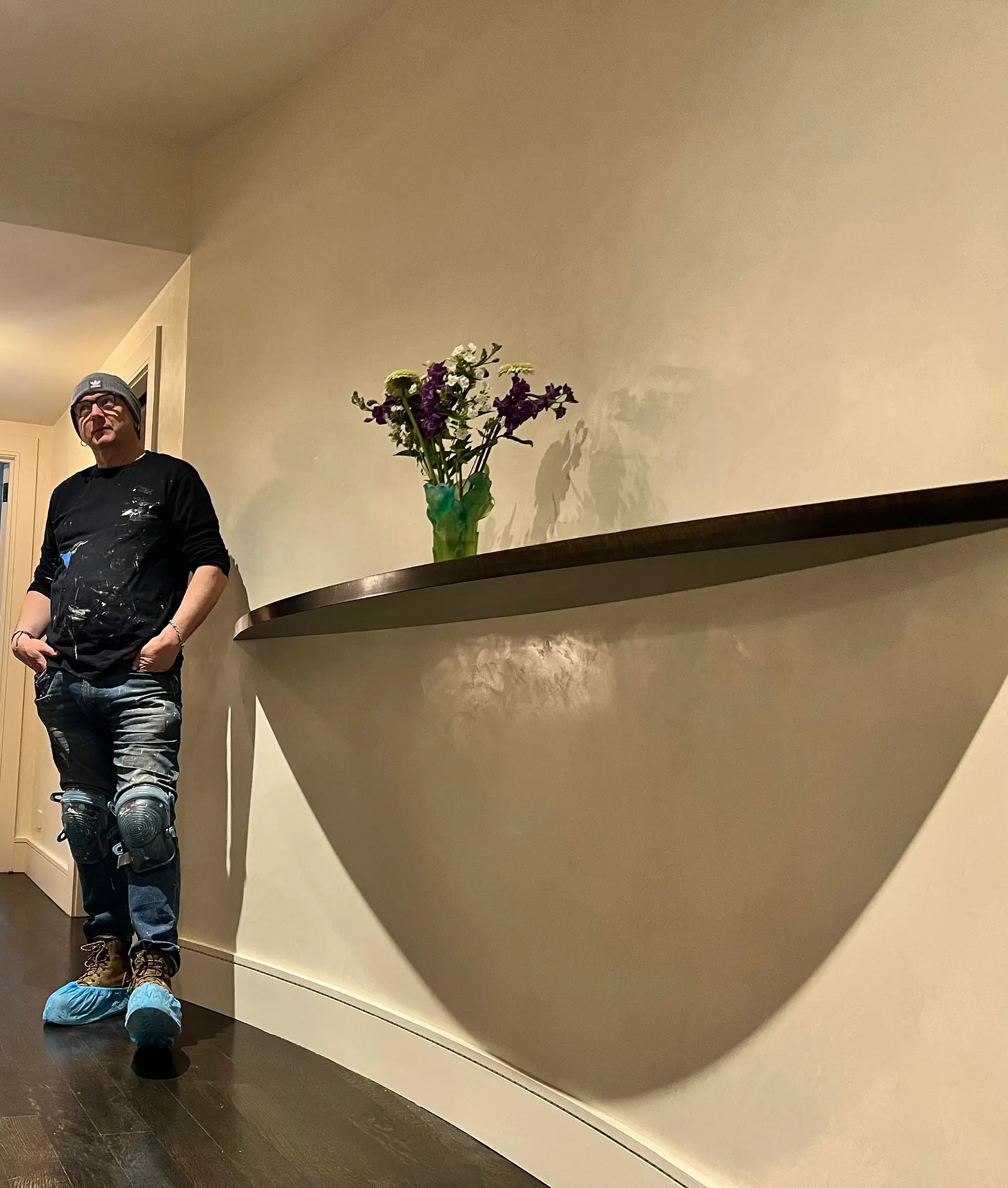 Conor Foy beside a curved polished plaster wall