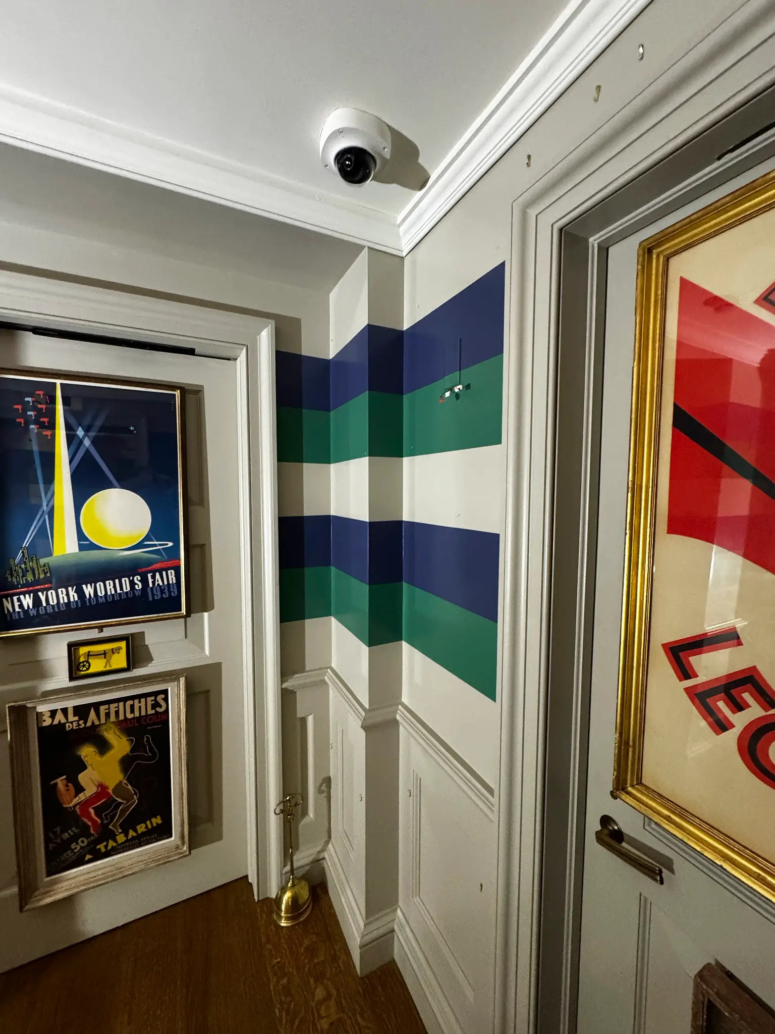Maxime's — corridor with hand-painted horizontal stripe over paneled wainscoting