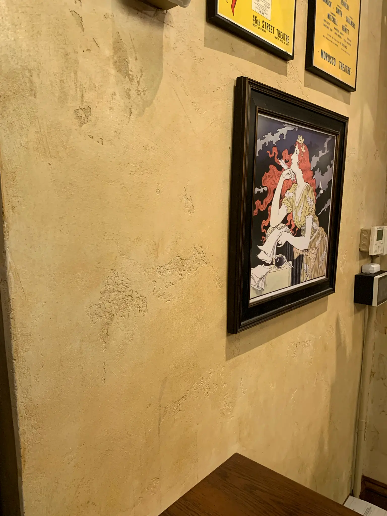 The Drama Book Shop — detail of the distressed plaster finish beside a framed theater poster